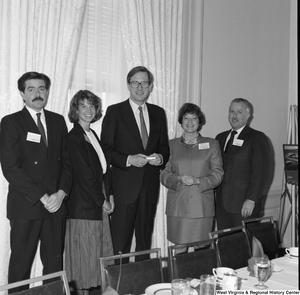 ["Senator John D. (Jay) Rockefeller stands with four representatives from the Charleston Convention Bureau during a luncheon."]%