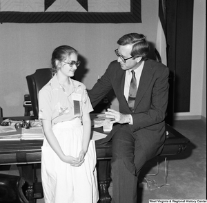 ["Photograph of Senator John D. (Jay) Rockefeller sitting on the corner of his desk with a participant in the Scripps National Spelling Bee."]%