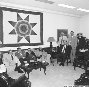 ["Senator John D. (Jay) Rockefeller sits surrounded by an unidentified group in his Washington office."]%