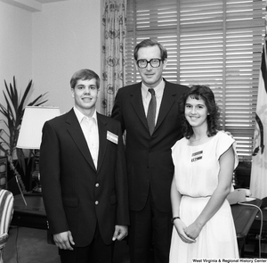 ["Senator John D. (Jay) Rockefeller stands for a photograph with two student participants in Youth for Understanding. The two students have name badges with their names and the Japanese translation of their names below."]%