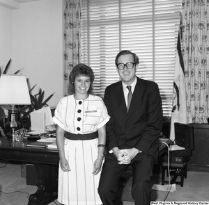 ["Senator John D. (Jay) Rockefeller sits on the corner of the desk in his office and poses for a photograph with a participant in the Washington Workshops program."]%