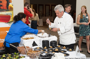 ["A chef prepares food at the 150th birthday celebration for West Virginia."]%