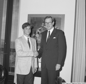["Senator John D. (Jay) Rockefeller shakes hands with an unidentified young man in his office."]%