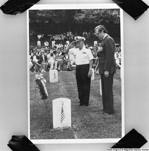 ["This is a photograph of a photo where Senator John D. (Jay) Rockefeller stands with his right hand over his heart during a ceremony at Grafton National Cemetery in Grafton, West Virginia. This photograph was taken in July 1985, but it is impossible to determine when the original photo was taken."]%