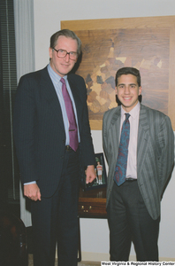 ["Senator John D. (Jay) Rockefeller stands next to a young man, possibly an intern, in his office."]%