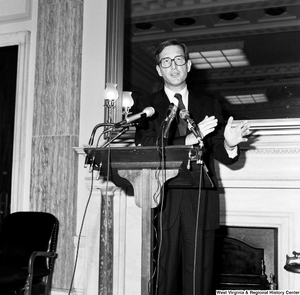 ["Senator John D. (Jay) Rockefeller speaks behind a podium at a press event in one of the Senate buildings."]%