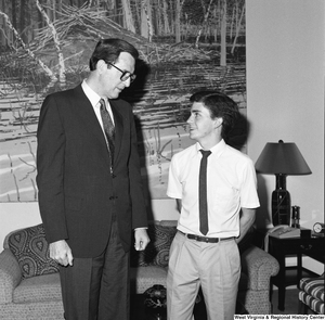 ["Senator John D. (Jay) Rockefeller and a young unidentified man look at one another in the Senator's office."]%