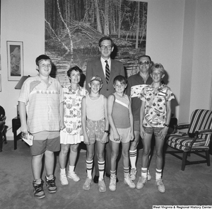 ["Senator John D. (Jay) Rockefeller stands with an unidentified family in his office."]%