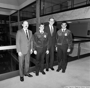 ["Senator John D. (Jay) Rockefeller stands with two members of Future Farmers of America and one unidentified man in a Senate office building."]%