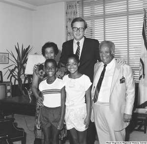 ["Senator John D. (Jay) Rockefeller stands in his office for a photograph with an unidentified family."]%