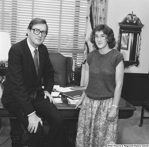 ["Senator John D. (Jay) Rockefeller sits on the edge of the desk in his Dirksen office and poses for a photograph with an unidentified individual."]%