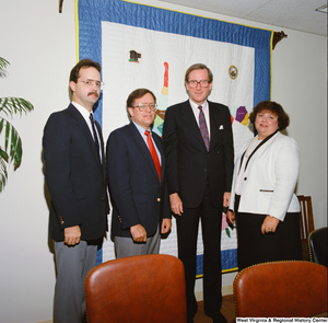 ["Senator John D. (Jay) Rockefeller stands with three unidentified individuals in his office."]%