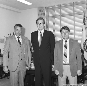 ["Two unidentified individuals stand with Senator John D. (Jay) Rockefeller in his office."]%