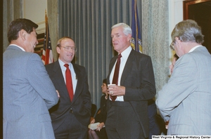 ["Unidentified men stand in a group at an event at the Senate."]%