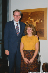 ["Senator John D. (Jay) Rockefeller stands next to an unidentified woman in the back of his office."]%