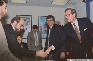 ["Senator John D. (Jay) Rockefeller shakes hands with a man following a business meeting."]%