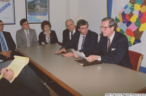 ["Senator John D. (Jay) Rockefeller reads a document during a business meeting in his office."]%