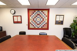 ["A quilt hangs on a wall behind a conference table in Senator John D. (Jay) Rockefeller's office."]%