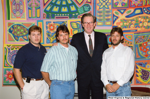 ["Senator John D. (Jay) Rockefeller stands with three men in front of the colorful quilt in his office."]%
