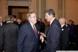 ["Senator Joe Manchin speaks with an unidentified man during his swearing-in ceremony."]%