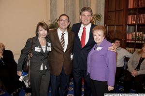 ["Senator Joe Manchin poses for a photograph with three individuals after his swearing-in ceremony."]%