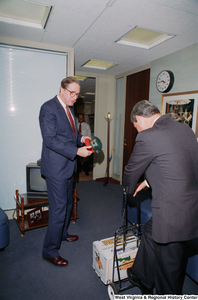 ["Senator John D. (Jay) Rockefeller receives a crate of Florida oranges from Florida Senator Bob Graham."]%
