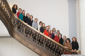 ["A group of women stand on a staircase inside the Senate."]%