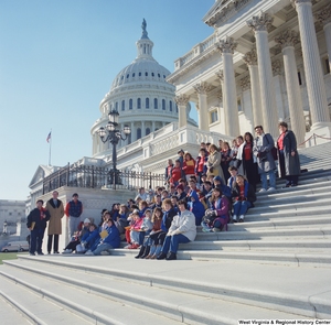 ["Senator John D. (Jay) Rockefeller stands on the steps of the Senate with a group of students."]%