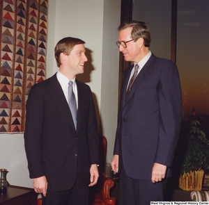 ["In this color photograph, Senator John D. (Jay) Rockefeller talks with an unidentified man in his office."]%