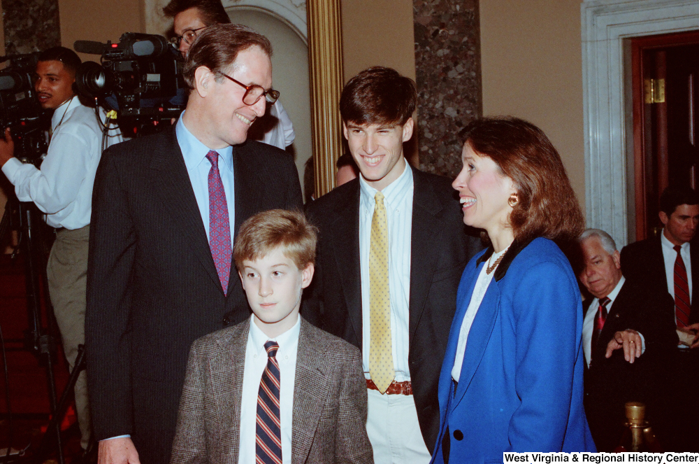 ["Senator John D. (Jay) Rockefeller stands with two of his sons and talks with an unidentified woman after his second Senate Swearing-In Ceremony."]%