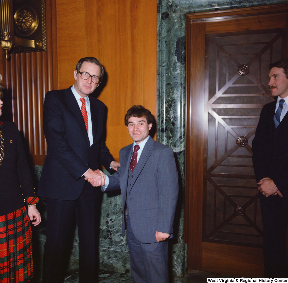 ["Senator John D. (Jay) Rockefeller greets an unidentified individual following the Senate Swearing-In Ceremony."]%