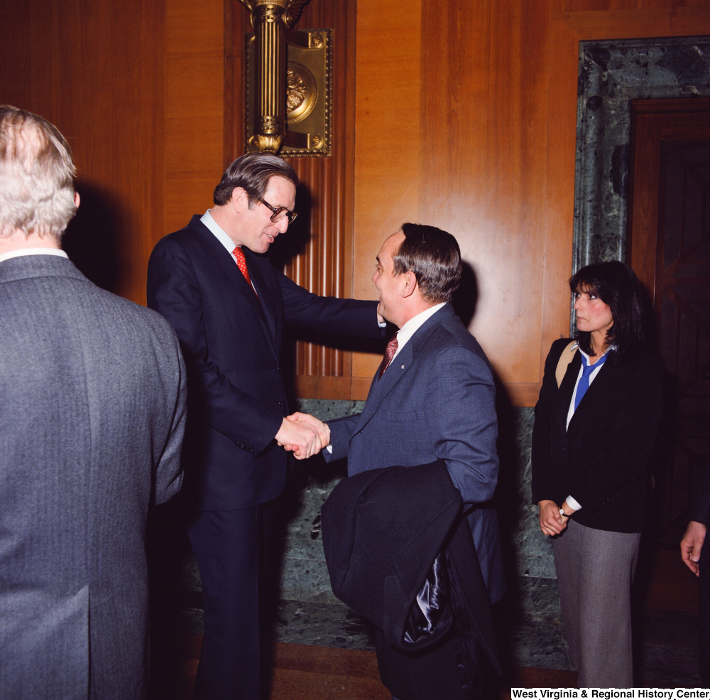 ["An unidentified supporter and Senator John D. (Jay) Rockefeller shake hands following the Senate Swearing-In Ceremony."]%