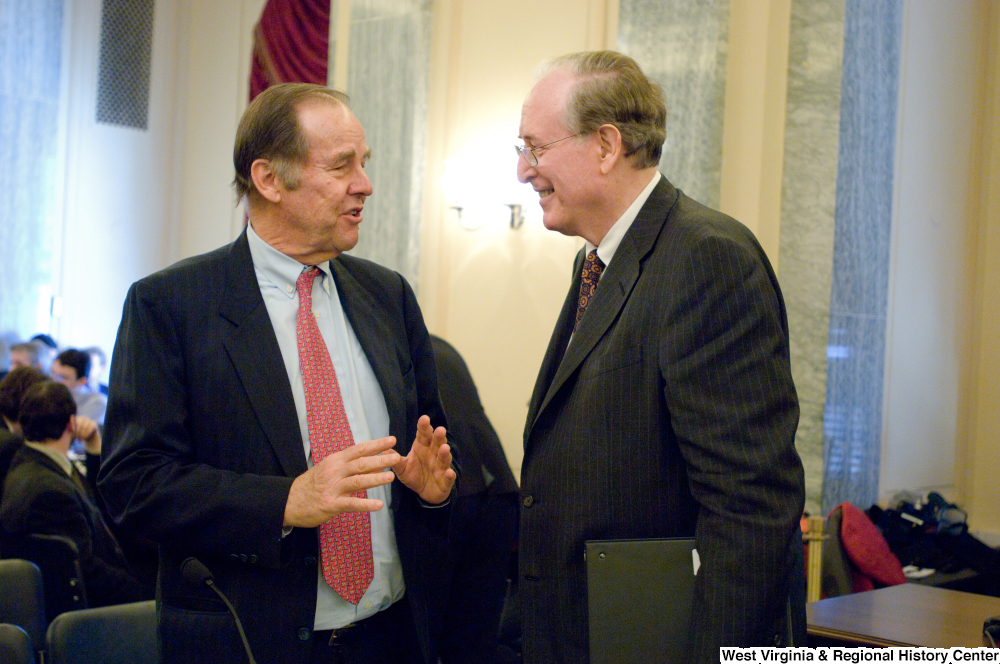 ["Senator John D. (Jay) Rockefeller talks with an unidentified man before a Commerce Committee hearing."]%