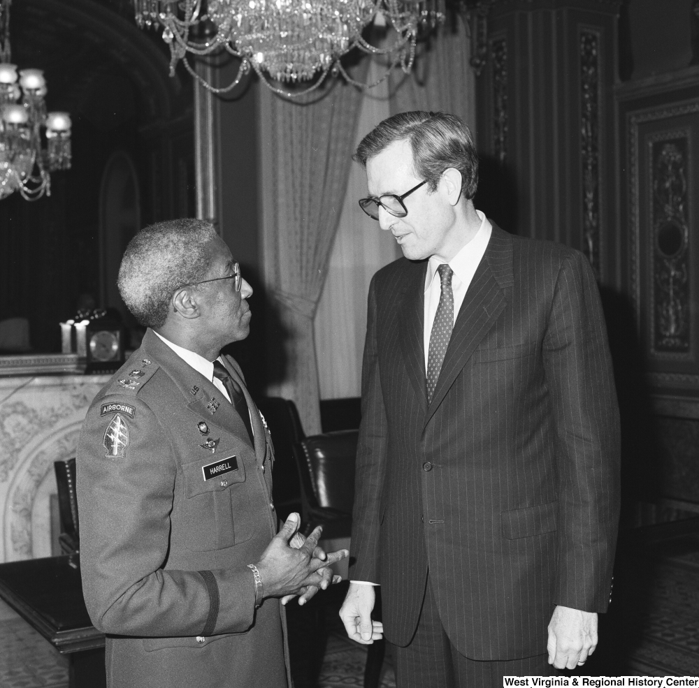 ["Senator John D. (Jay) Rockefeller speaks with Major General Ernest Harrell in a Senate building."]%