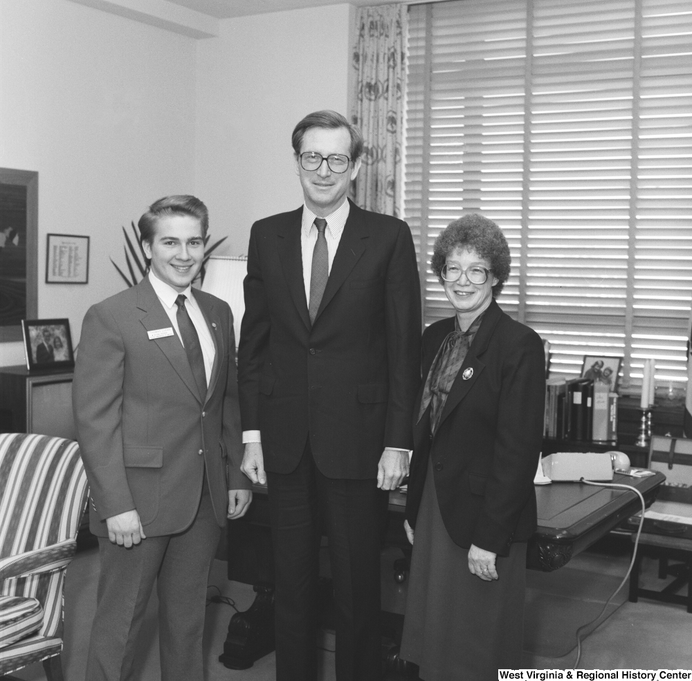 ["Senator John D. (Jay) Rockefeller stands with two unidentified individuals in his office. The boy in the left part of the photograph has a name badge on that says \"Thomas Lucas\", but the rest of the text is indistinguishable and it is not known what kind of group he is representing."]%