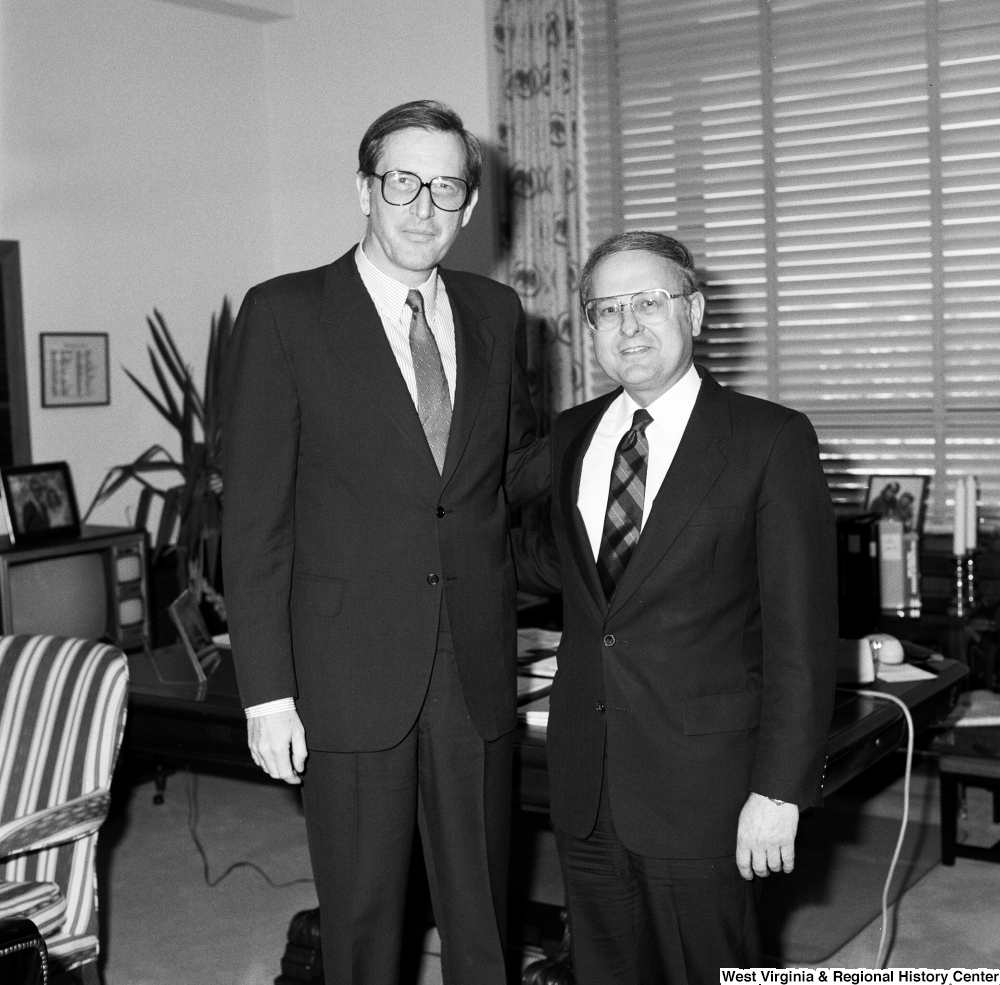 ["Senator John D. (Jay) Rockefeller and an unidentified man stand for a photograph in the Senator's office."]%