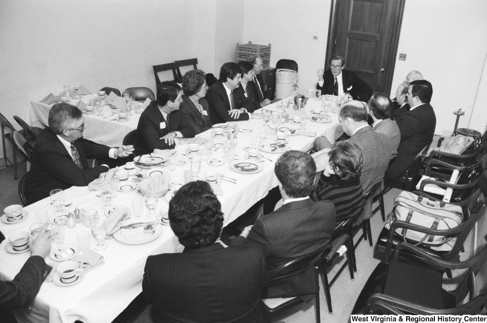 ["Senator John D. (Jay) Rockefeller sits at the head of the table during a breakfast banquet in the Senate."]%
