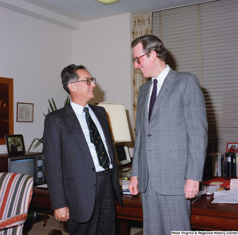["This color photograph shows Senator John D. (Jay) Rockefeller speaking with an unidentified individual in his office."]%