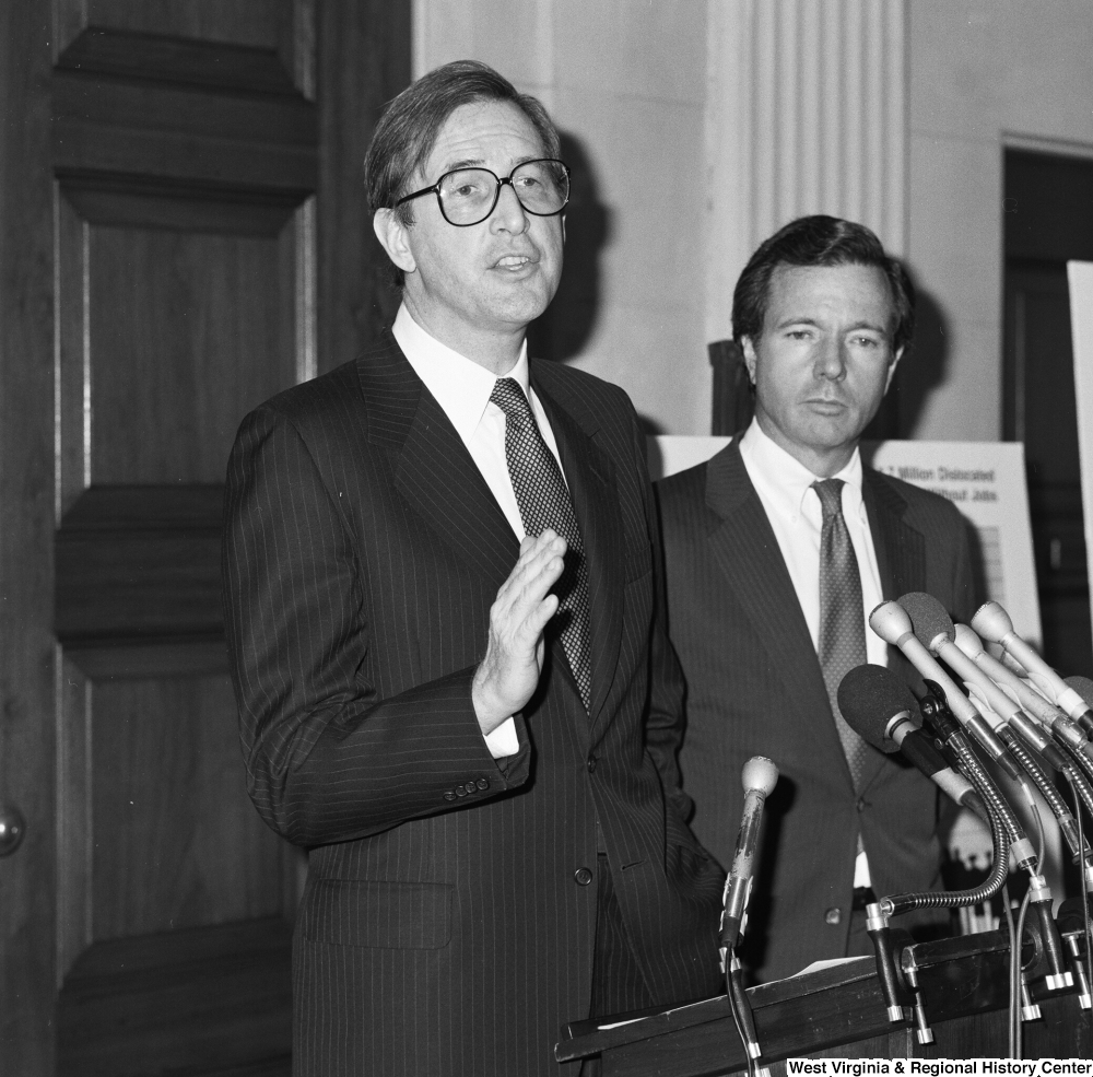 ["Senator H. John Heinz III stands behind Senator John D. (Jay) Rockefeller as he speaks at a press event supporting the Dislocated Workers Improvement Act of 1987."]%