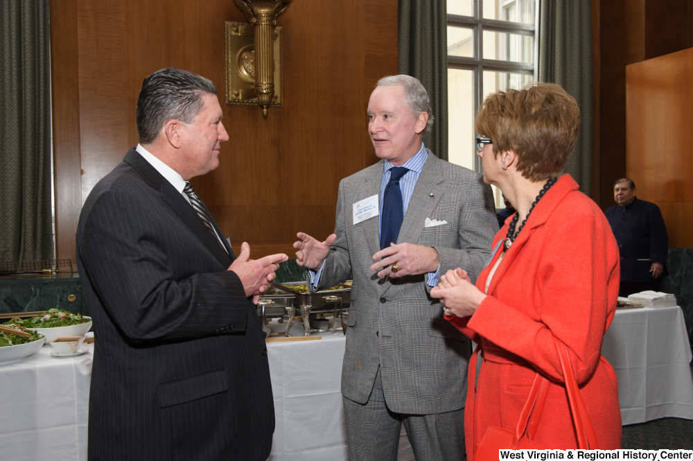["A man talks with two other people at a Welcome to Washington luncheon."]%