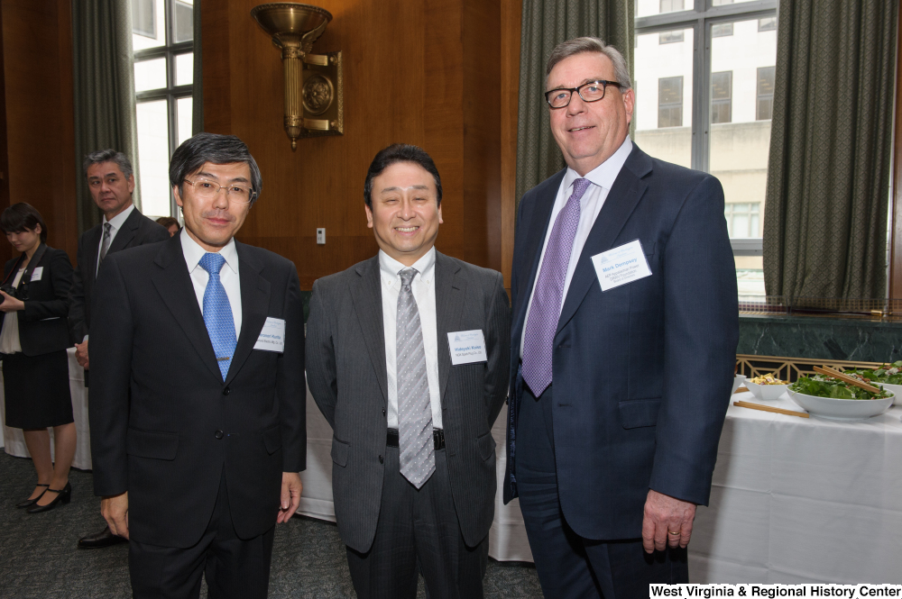 ["Industry leaders stand together for a photo at a Welcome to Washington luncheon."]%