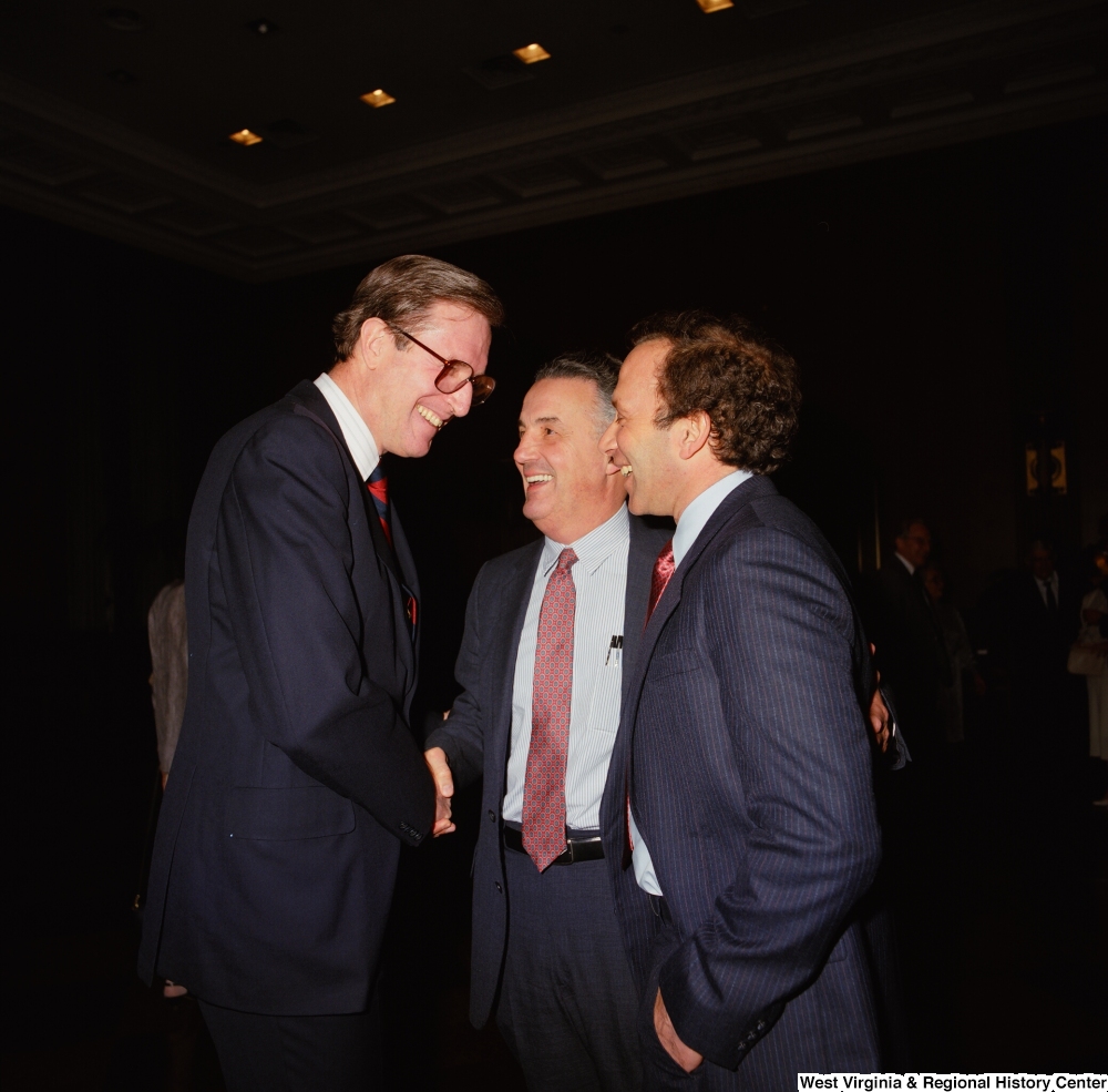 ["Senator John D. (Jay) Rockefeller shakes hands and laughs with staff members during an event in the Senate."]%