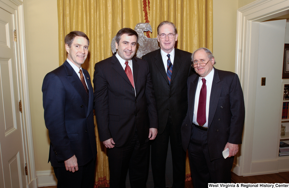 ["Senator John D. (Jay) Rockefeller poses for a photograph with three unidentified men after a luncheon in the Senate."]%