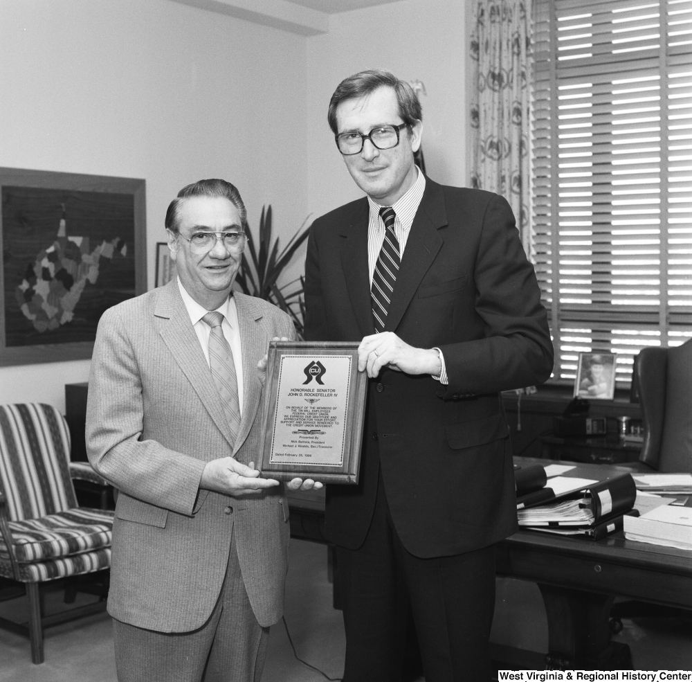["Senator John D. (Jay) Rockefeller holds his award plaque and poses for a photograph with an unidentified representative of the Tin Mill Employees Federal Credit Union."]%