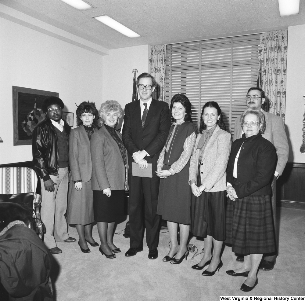 ["Senator John D. (Jay) Rockefeller holds an envelope and poses for a photograph with representatives from the West Virginia Association of Community Health Centers."]%