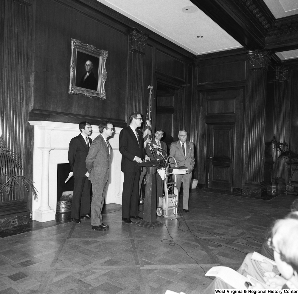 ["This photograph was taken from a distance, but shows Senator John D. (Jay) Rockefeller speaking at a Staggers Rail Reform press event in a Senate building."]%