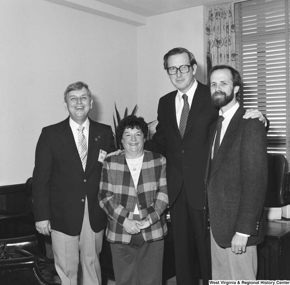 ["Senator John D. (Jay) Rockefeller poses for a photograph with an unidentified group of three visitors in his Washington office."]%