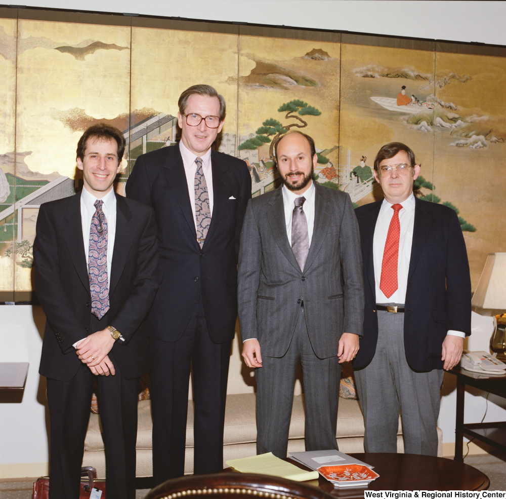 ["Senator John D. (Jay) Rockefeller stands next to three unidentified men in his office."]%