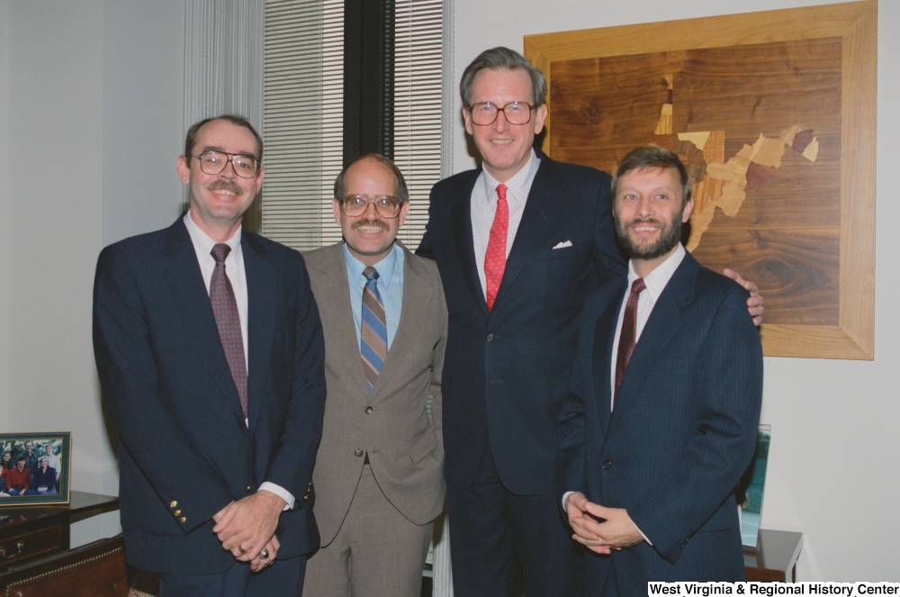 ["Senator John D. (Jay) Rockefeller stands with three unidentified men in his office."]%