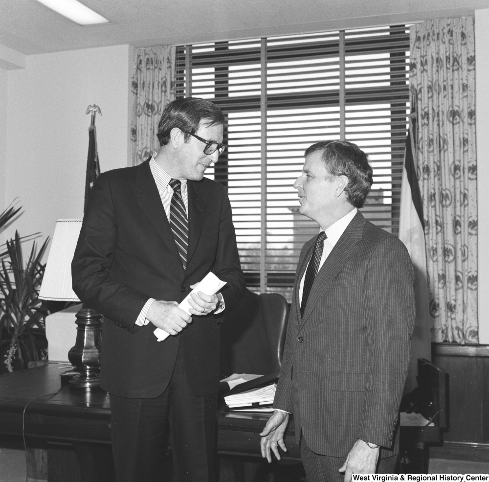 ["Senator John D. (Jay) Rockefeller holds a rolled up piece of paper as he speaks with FEMA Assistant Director Sam Speck in his Washington office."]%